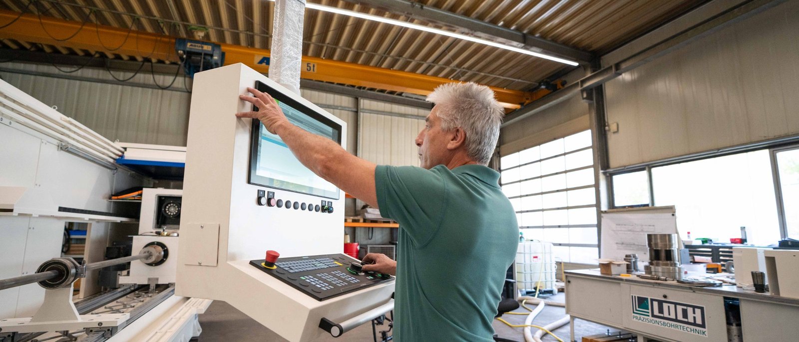 Kollege an einer Tiefbohrmaschine in der Halle